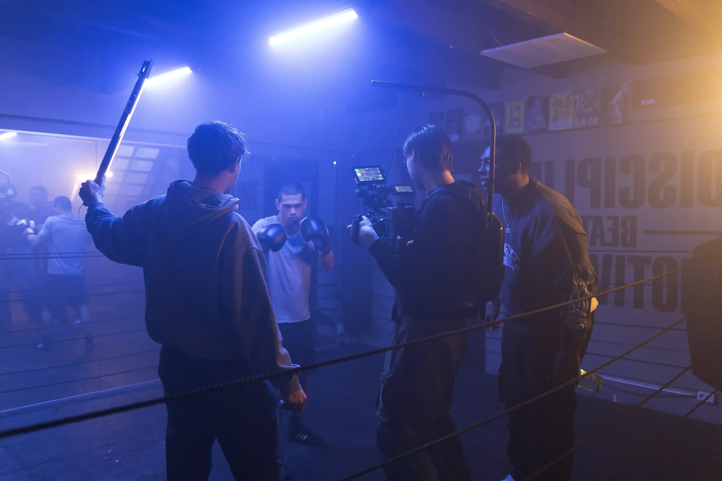 Crew aan het draaien in een boksschool, met camera en lamp