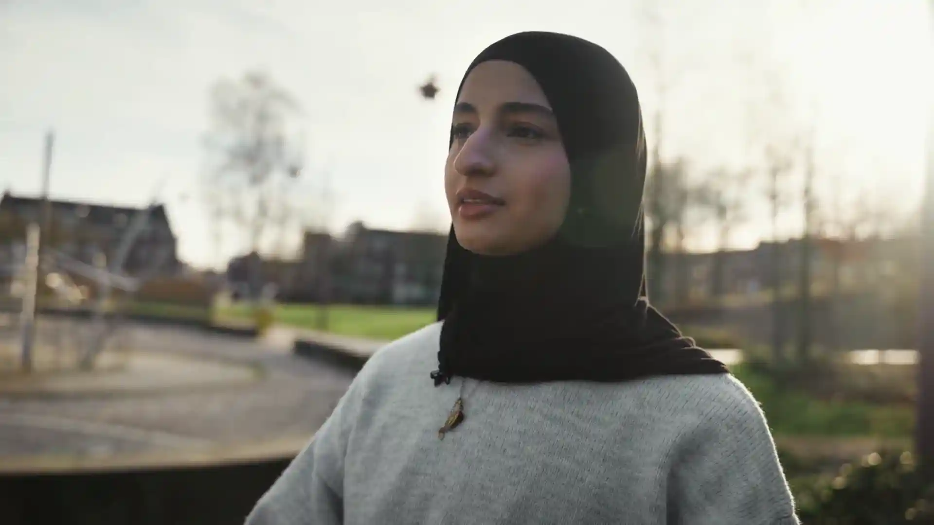 Still from a video: a young woman outdoors, talking to camera